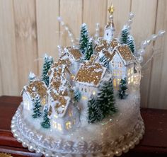 there is a cake decorated with small houses and trees