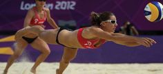 two women are playing volleyball on the beach