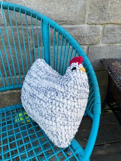 a blue chair with a chicken pillow on it