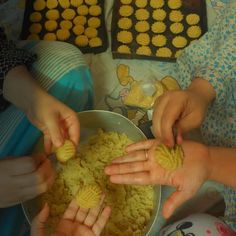 three children are playing with cookies in a bowl