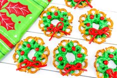 christmas pretzels decorated with holiday decorations and candy are on a table next to a green napkin