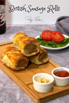 sausage rolls on a cutting board with dipping sauces