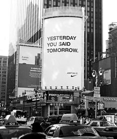 black and white photograph of billboard on the side of a building in new york city