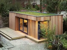 a small wooden building with a green roof