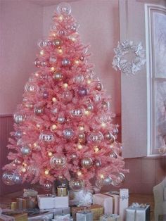 a pink christmas tree with presents under it