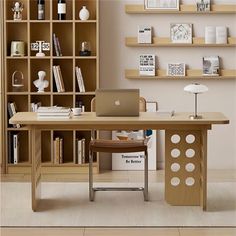 a desk with a laptop computer on it in front of a book shelf filled with books