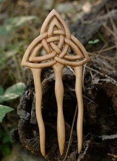 a wooden object with an intricate design on it's side sitting in the woods