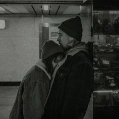 a man and woman standing next to each other in front of a glass display case