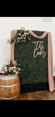 the cook's sign is next to a wooden barrel with flowers and greenery on it