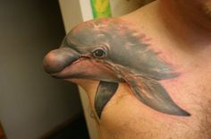 a man with a dolphin tattoo on his chest