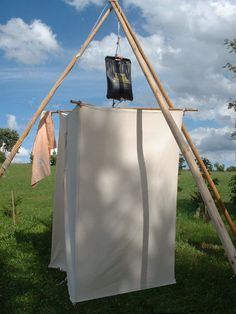 a tent with clothes hanging from it in the grass