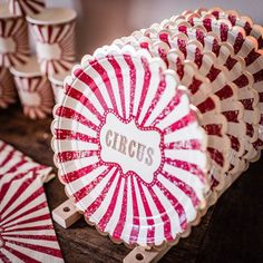 red and white striped paper plates with personalized name on them sitting on a wooden table