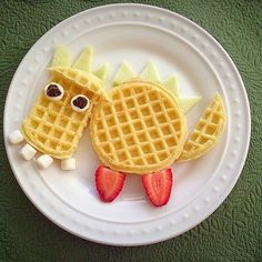 a white plate topped with waffles and strawberries on top of each other