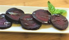 sliced beets on a white plate with a green leaf