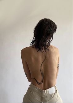 the back of a woman's body with tattoos on it