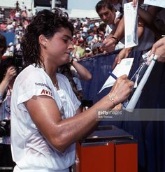 the tennis player signs autographs for fans