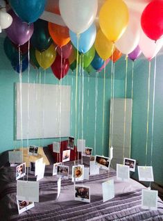 balloons are floating in the air over a table with pictures and photos on it's sides