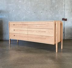 a large wooden dresser sitting on top of a cement floor next to a concrete wall