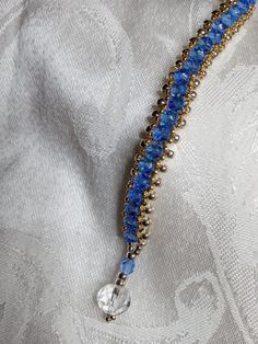 a blue beaded necklace on a white fabric