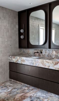 a bathroom with marble counter tops and double mirrors