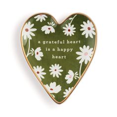 a green heart shaped brooch with white daisies and the words, a grateful heart is a happy heart