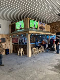 people are standing around watching televisions in a building