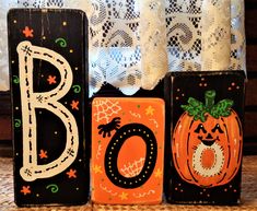 three wooden blocks decorated with pumpkins and the letter b