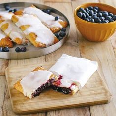 two pastries on a cutting board with blueberries