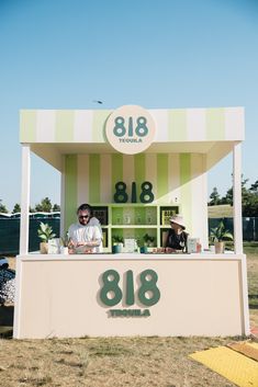 a man standing behind a booth selling food