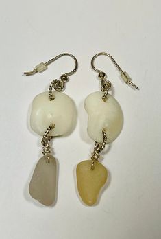 "Sea glass lucky stone dangle earrings. One is lavender and the other one is a beige. The lucky stones are an ivory like stone (inner ear bone of a sheep head fish). They measure 2 1/2\" length, I used twisted silver plated jump rings for the connectors. The ear wire is also silver plated with plastic backings.  Awesome gift idea for the upcycling, ecofriendly, beach lover in your life.  Perfect for a beach wedding! Check out my other items at www.etsy.com/shop/pierbeachglass My sun catchers hav Nickel-free Glass Jewelry For Beach, Elegant Recycled Glass Earrings With Ear Wire, Nickel-free Glass Jewelry For The Beach, Cream Teardrop Earrings For Gift, Handmade White Glass Earrings, Adjustable Cream Drop Earrings, White Sea Glass Jewelry Gift, White Teardrop Earrings For Beach, Clear Glass Jewelry For Beach