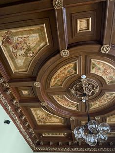 an ornate ceiling with chandelier and paintings on the walls in a room that looks like it has been painted