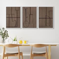 two paintings hang on the wall above a dining room table with chairs and vases