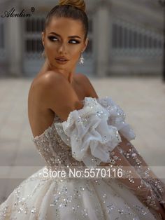 a woman in a wedding dress posing for the camera with her hand on her shoulder