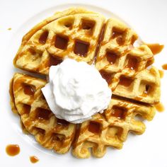 waffles with whipped cream and caramel syrup on a white plate