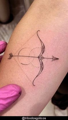 a woman's arm with an arrow tattoo on it