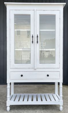 a white cabinet with two glass doors on it