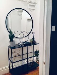 a mirror sitting on top of a table next to a potted plant and candle