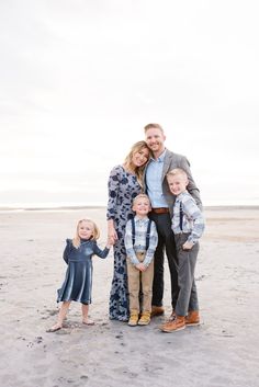 a family posing for a photo on the beach