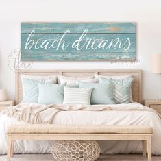 a bedroom with a bed and pillows on the floor, along with a large wooden sign that says beach dreams