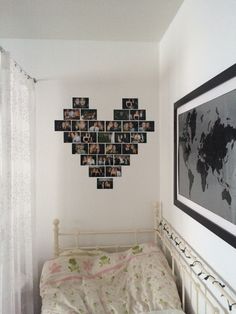 a white bed in a bedroom next to a wall with pictures on it and a framed world map