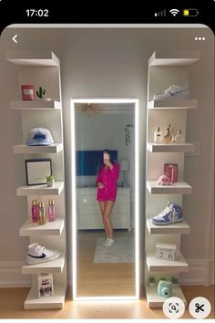 a woman standing in front of a mirror next to white shelves with shoes on them