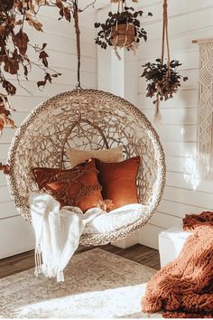 a hanging chair with pillows and blankets on it