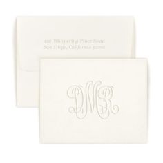 two white envelopes with monogrammed letters on them