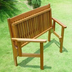 a wooden bench sitting on top of a lush green field