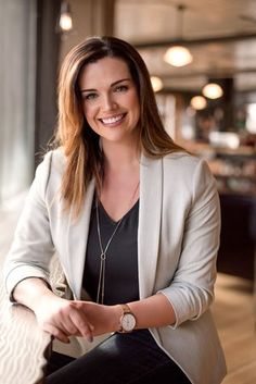 a woman sitting on top of a wooden floor next to a window in a building