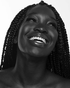 a woman with braids smiling at the camera