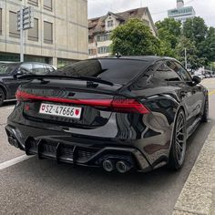 a black sports car parked on the side of the road in front of some buildings