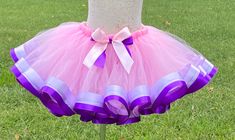 Celebrate any occasion in this ribbon trimmed tutu . Perfect for parties, celebrations,  recitals, dance and every day wear. Tutus are made on a stretch elastic for a comfortable fit.  Ribbon is sewn on. Your little one will be the center of attention in this beautiful tutu. If you would like another color combination or a size other than what is listed please send me a message. If you need your order faster than my current turnaround you will need to purchase the Rush My Order listing as well. Purple Princess Tutu Dress For First Birthday, Cute Purple Tutu Dress For First Birthday, Purple Cute Tutu Dress For First Birthday, Cute Purple Tutu Dress For Birthday, Purple Tulle Tutu Dress For Birthday, Purple Cute Tutu Dress For Birthday, Purple Smash Cake, Ribbon Tutu, Tutu Pink