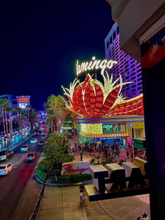 the las vegas sign is lit up at night with cars driving down the street below