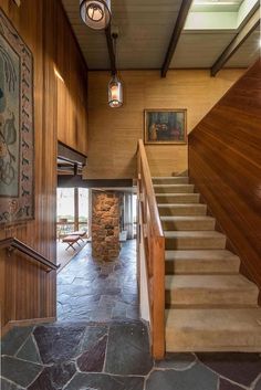 an entry way with stone steps and wood paneling